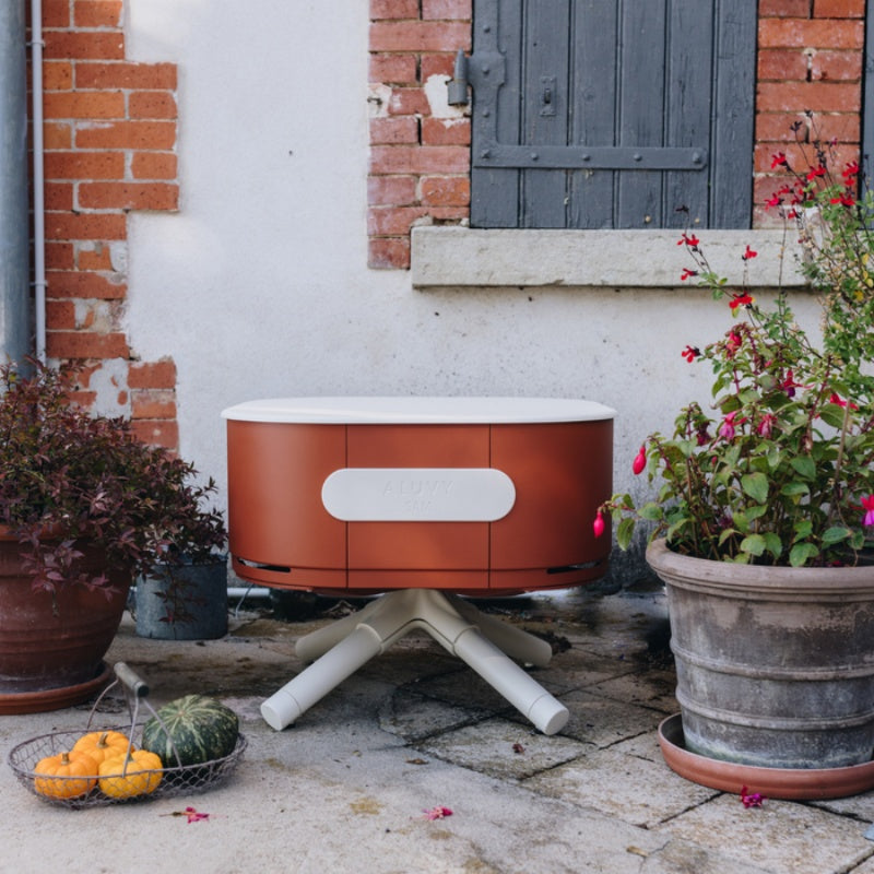 ALUVY SAM Original Low Brazier Terracota near a brick wall and planters
