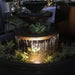 Corner Bowl Fountain rust with lights and floating plants at night