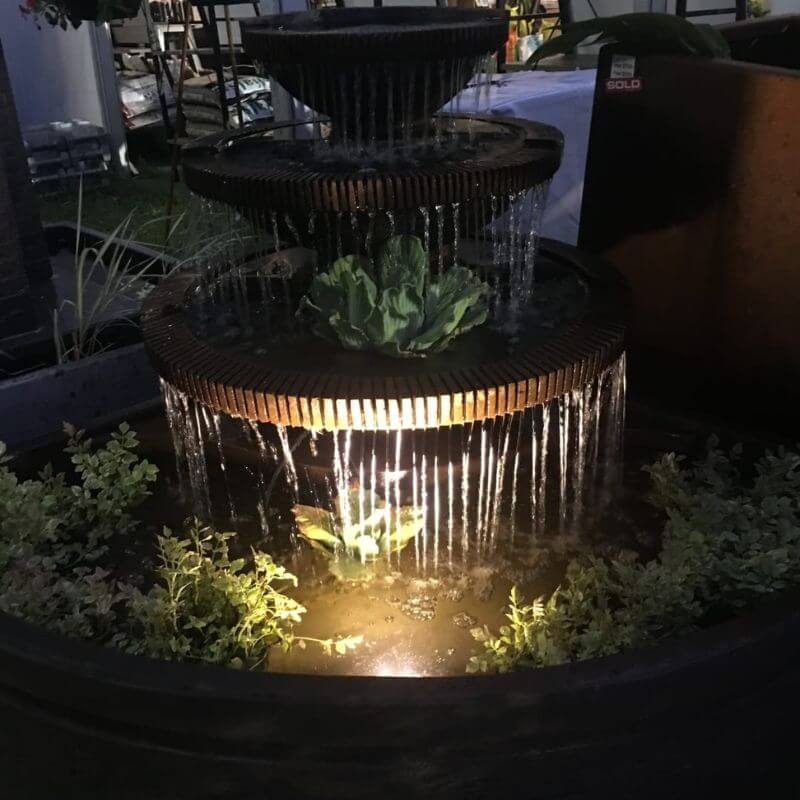 Corner Bowl Fountain rust with lights and floating plants at night