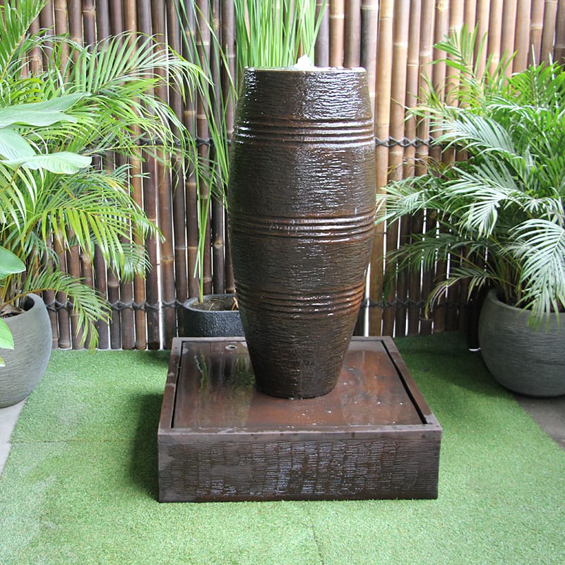 Galleria's cuban water fountain in rust front view amongst greenery