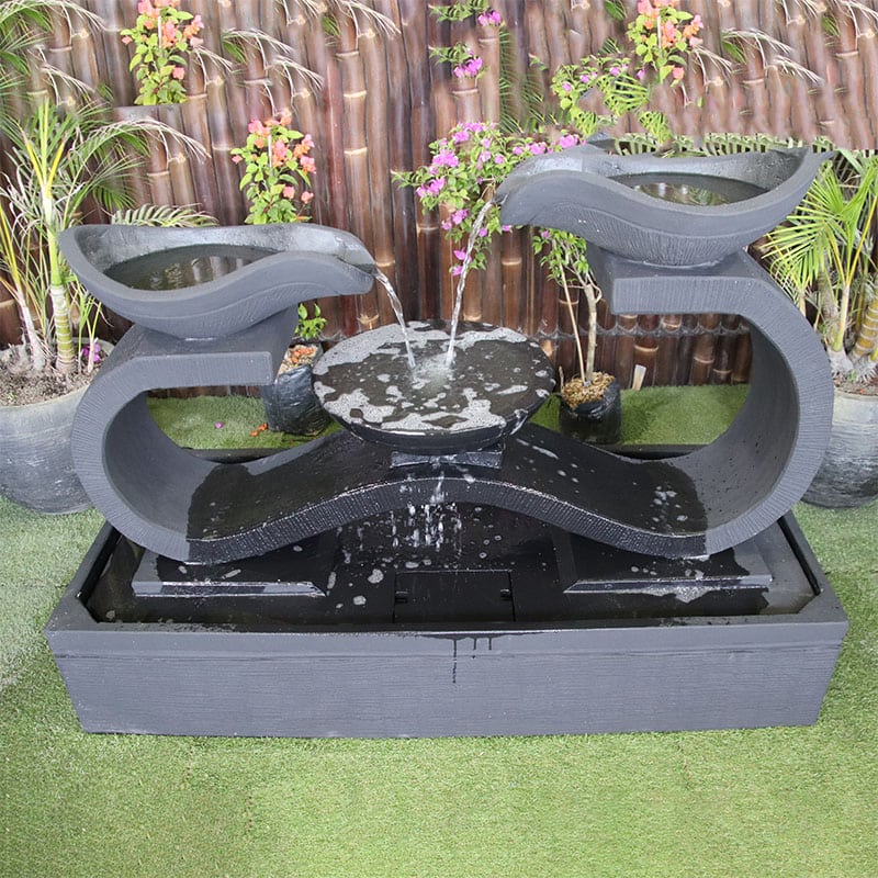 Infinity fountain top view in charcoal with flowers and leaves in the background