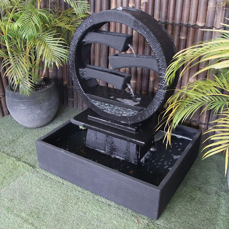 Galleria Imports Wagon Wheel Fountain medium charcoal right angle view with plants