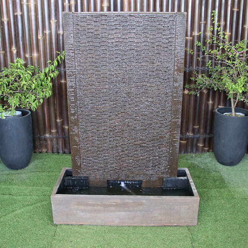 Galleria Ripple Wall Fountain in rust with pot plants