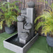 Streaming Pots Fountain by Galleria Imports in large grey right angle view amongst greenery