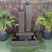 Galleria Imports Twin Column Fountain in rust front view in the garden