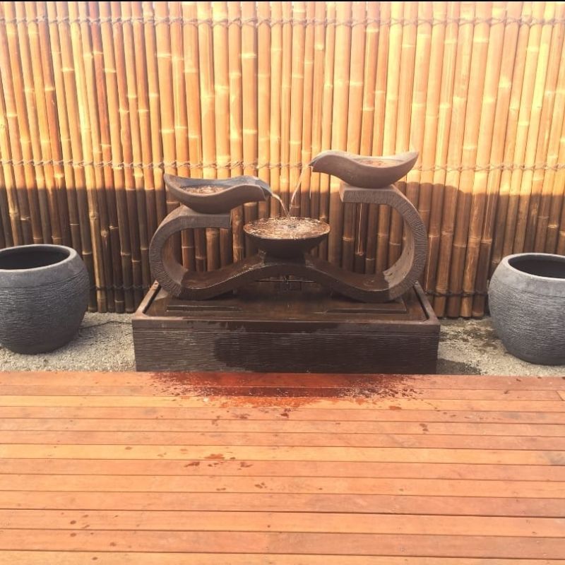 Infinity Fountain in Rust with bamboo background and deck