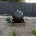 Large Luna Ball in Rust with crushed rocks and wooden fence