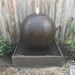 Luna Ball Fountain Small in Rust with wooden fence in the background