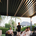 Luxi Living Baltic Motorised Freestanding Louvre Roof Aluminium Pergola - people under the pergola