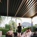 Luxi Living Tasman Motorised Freestanding Louvre Roof Aluminium Pergola - people under the pergola