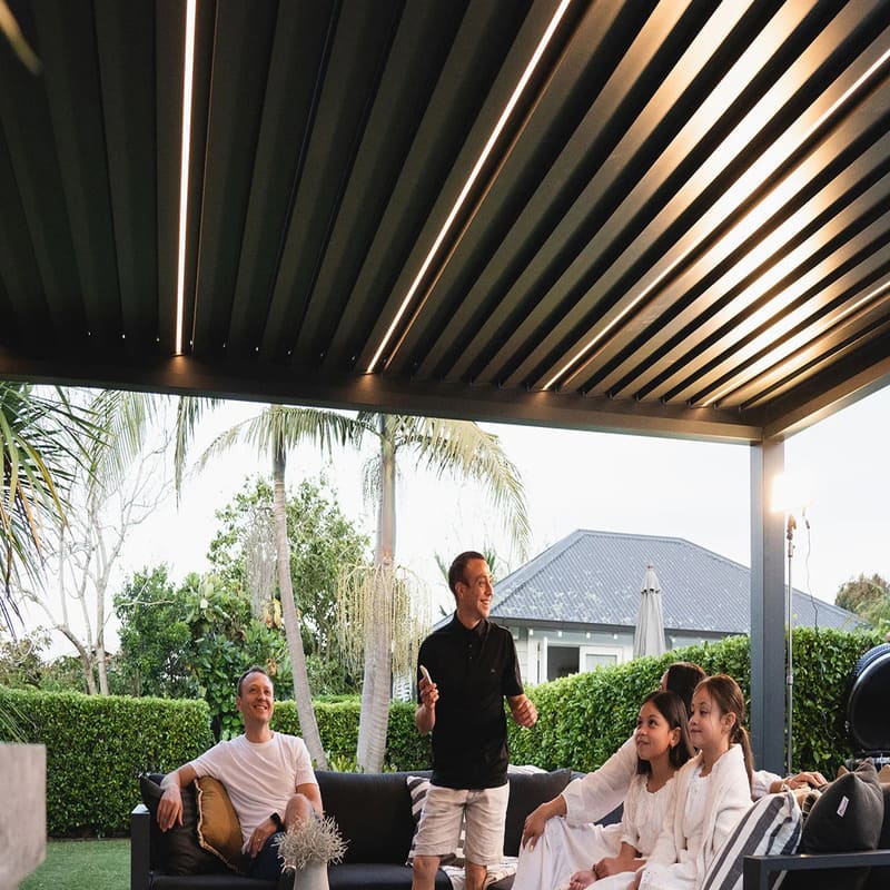 Luxi Living Tasman Motorised Freestanding Louvre Roof Aluminium Pergola - people under the pergola