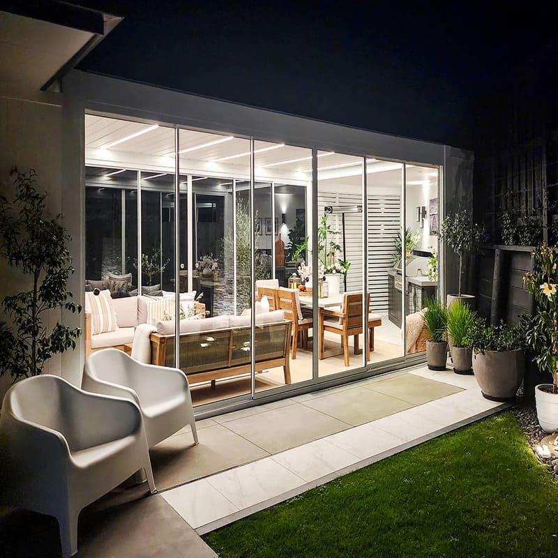 Luxi Living Tasman Motorised Freestanding Louvre Roof Aluminium Pergola - illuminated pergola at night time.