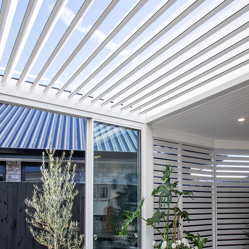 Luxi Living Tasman Motorised Freestanding Louvre Roof Aluminium Pergola - white pergola opened with plants underneath