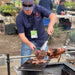 Pinnacle BBQ Firepit cutting meat from the spit to the hotplate