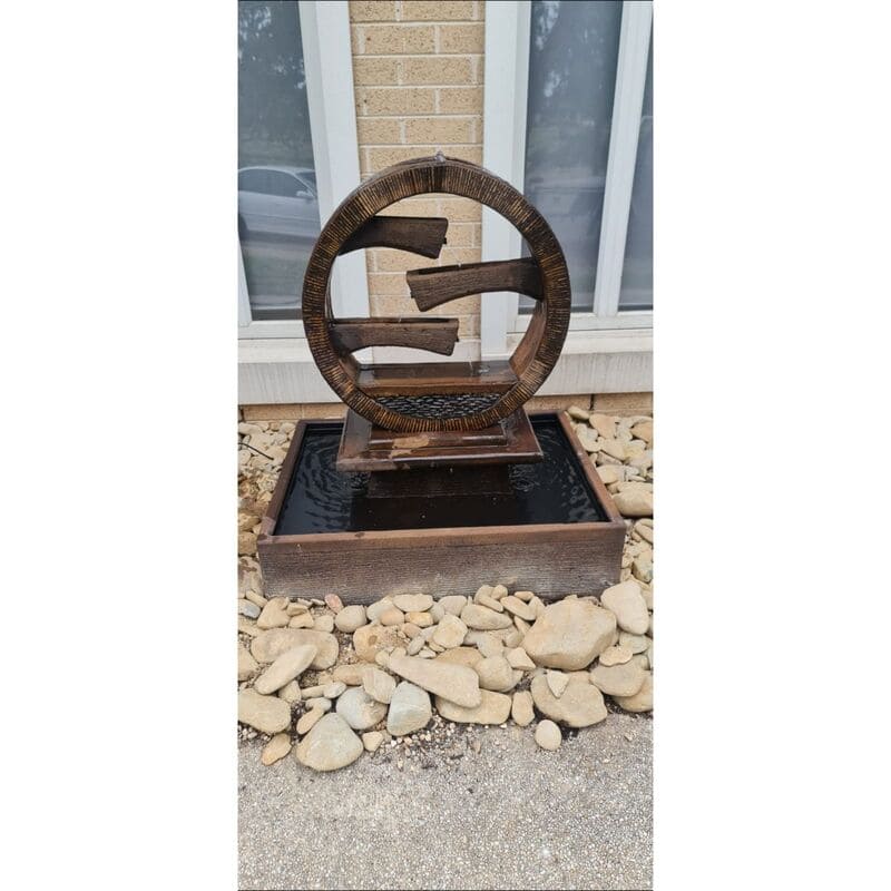 Wagon Wheel Fountain Large rust with rocks surround
