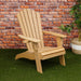 Winawood Adirondack Armchair- New teak chair on green carpet with brick wall behind.