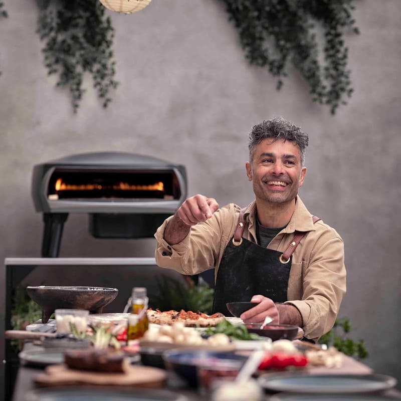 Witt Etna Rotante Gas Powered Pizza Oven with Twin Burner & Rotating Stone 16" - Chef sitting at the table served with food.