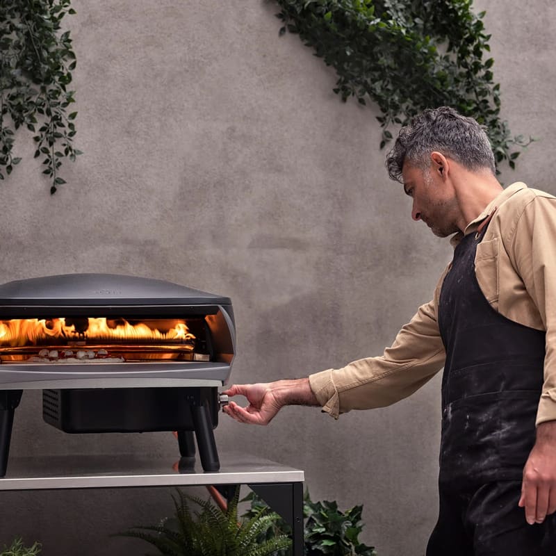 Witt Etna Rotante Gas Powered Pizza Oven with Twin Burner & Rotating Stone 16" - chef putting on the oven.