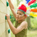 Wooden Climbing Cube with slide a boy climbing on the wall