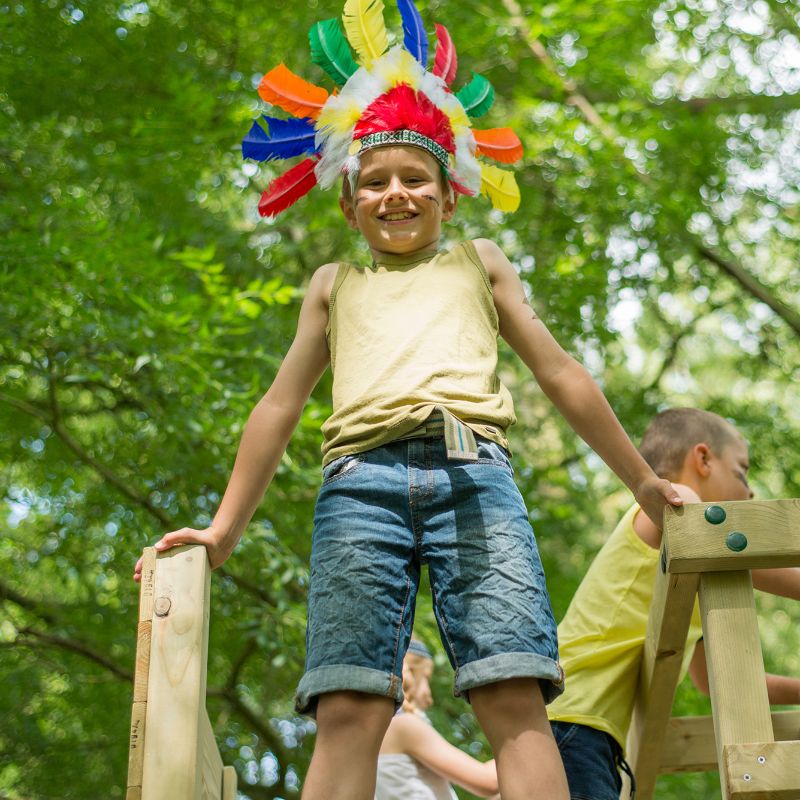 Wooden Climbing Cube with slide a kid smiling on top of the cube