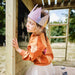 A girl hiding behind the Wooden lookout tower with ladder at the back