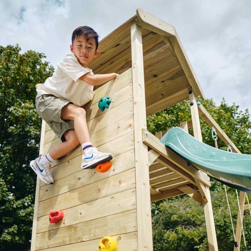 Boy on the top of the Wooden Lookout Tower with Slide