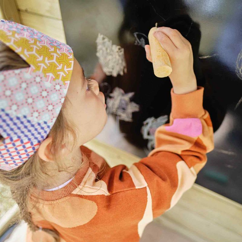 a girl drawing on a blackboard with chalk